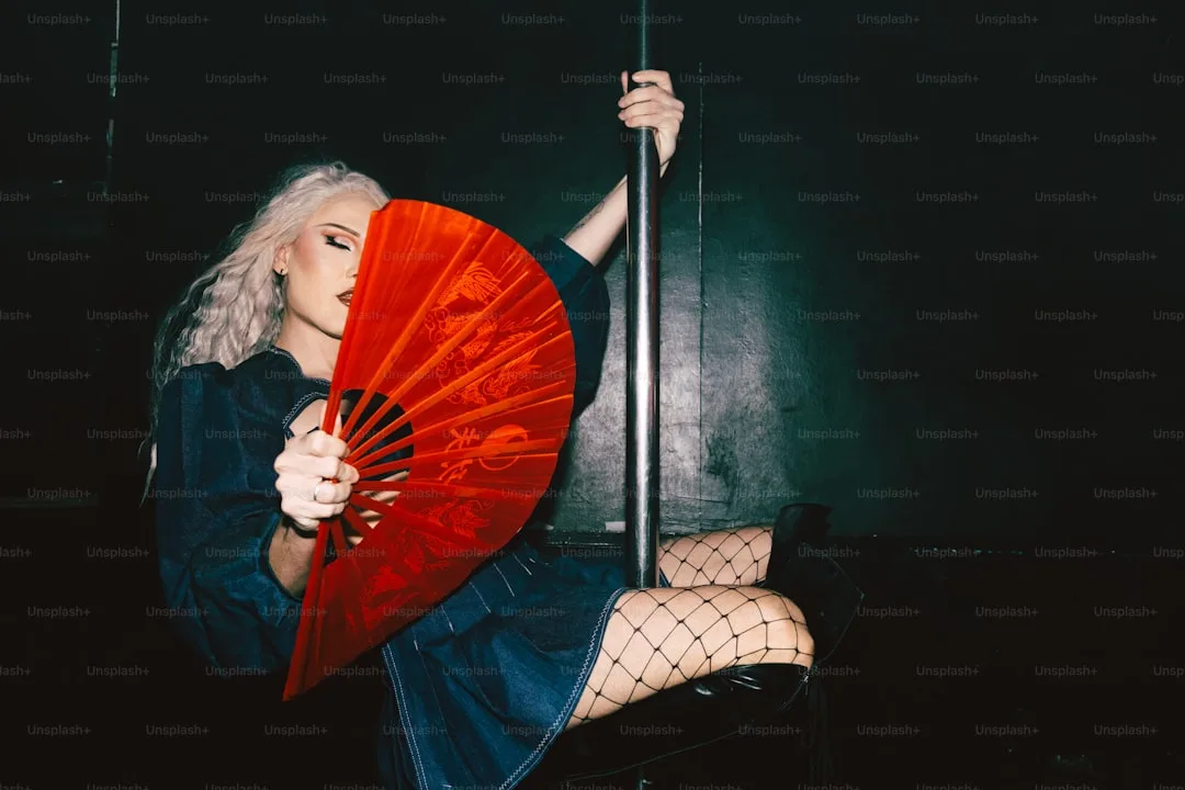 Une femme tenant un parapluie rouge assise sur une chaise